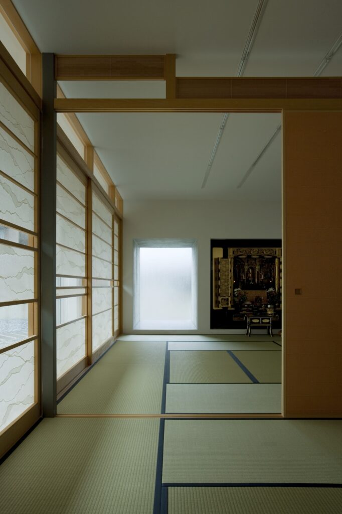 滑动的天然木板将每个房间分开，而纸遮阳的窗户向左打开，可以看到内部的庭院。