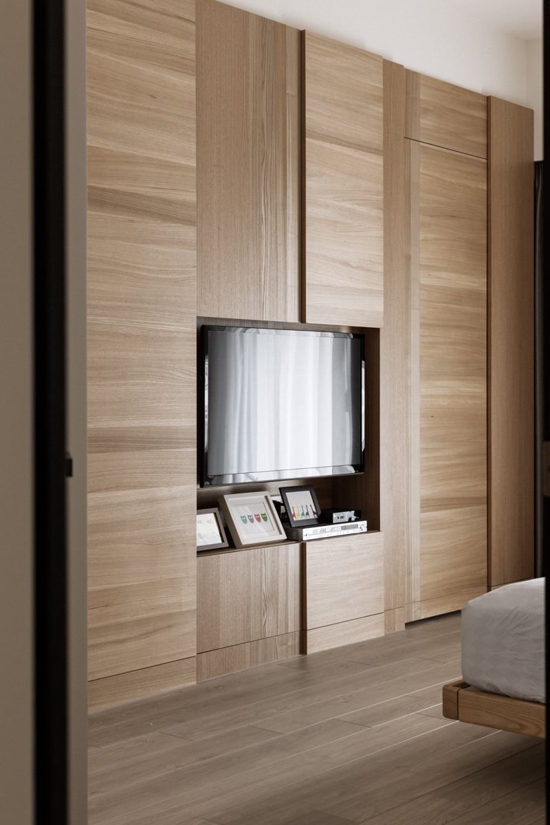卧室继续全高度木质镶板和橱柜的区域,在这里与一个微妙的断路空间电视前的木框架的床。
