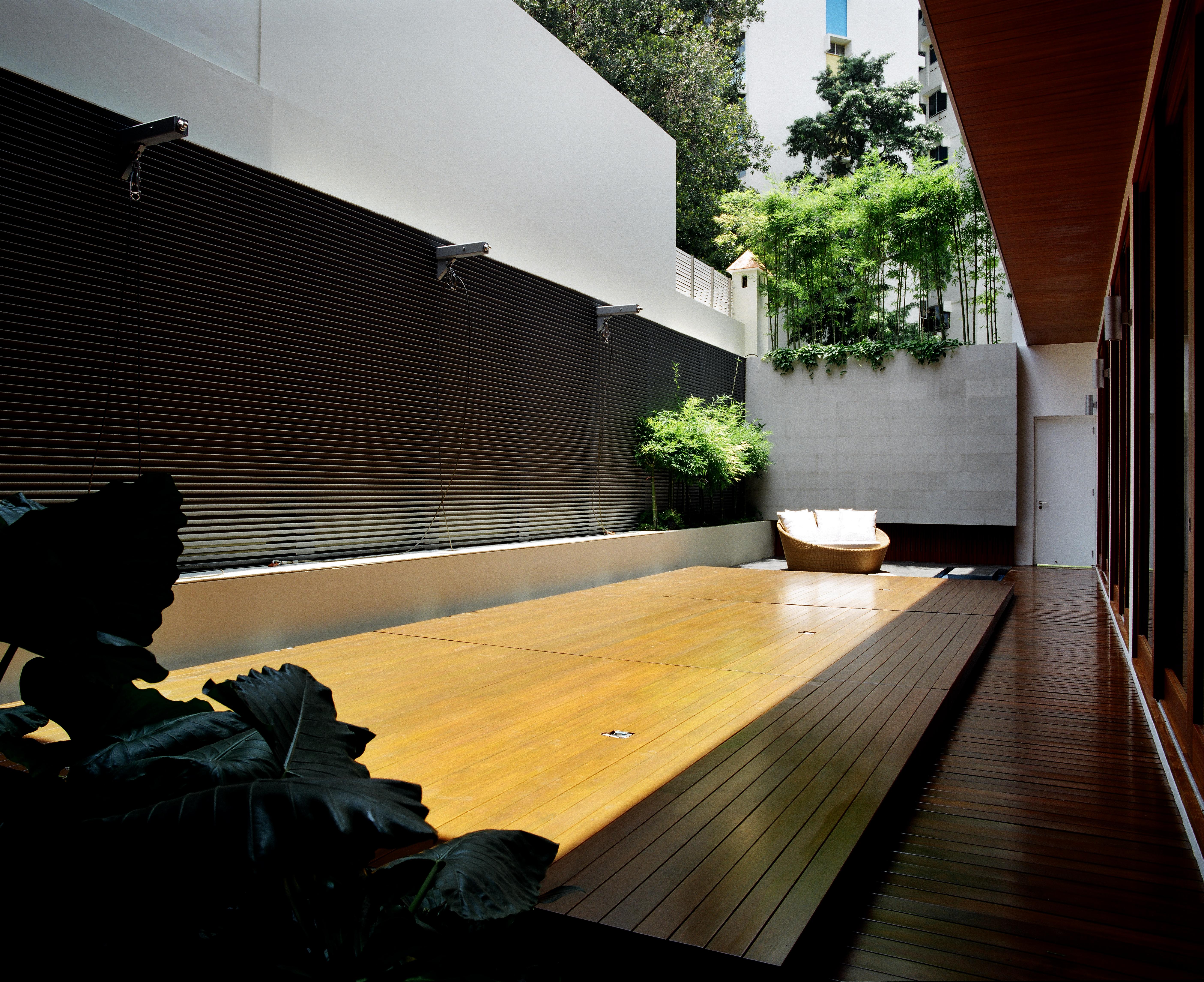 从封闭的位置看，泳池甲板创造了一个凸起的硬木平台，扩展了庭院的宜居空间。