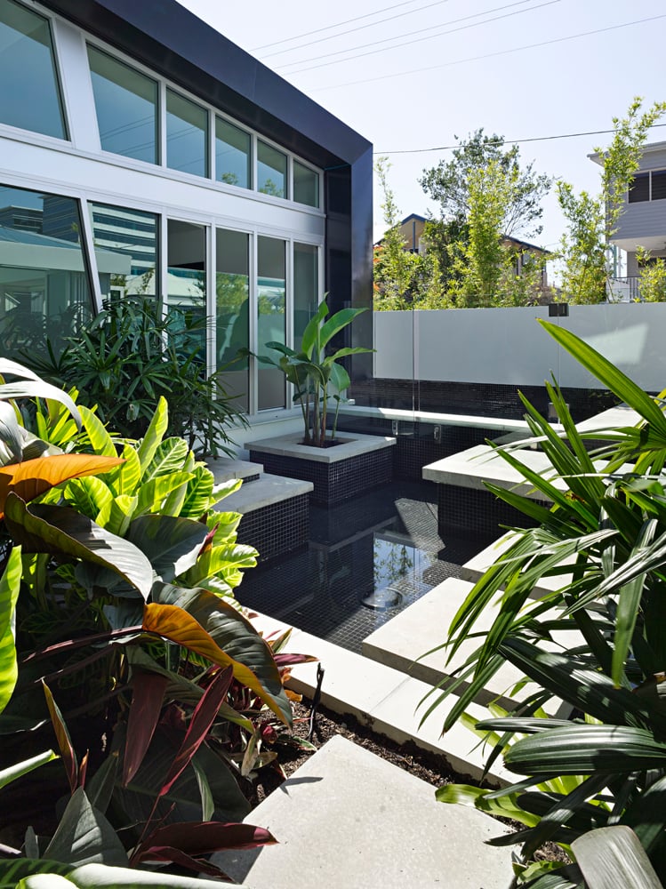 这个屋顶花园的特点是一个被绿色植物包裹的分层喷泉，就在环绕的滑动玻璃板外面。