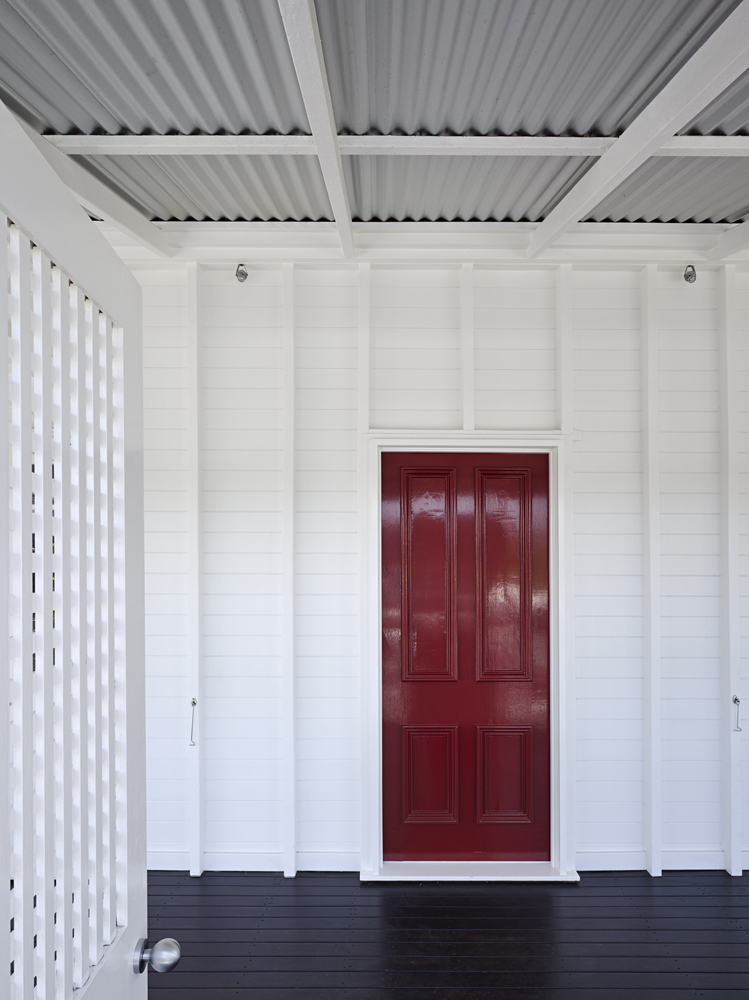醒目的红色前门与周围房屋柔和的方向分开。