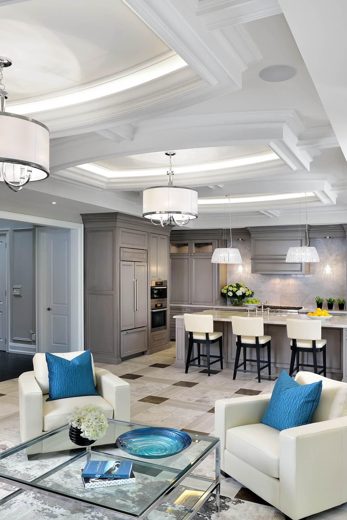中央开放空间共用客厅和厨房，大面积的瓷砖地板将各种色调的大理石搭配成复杂的图案。白色皮革扶手椅在中性主题中闪耀着大胆的蓝色。