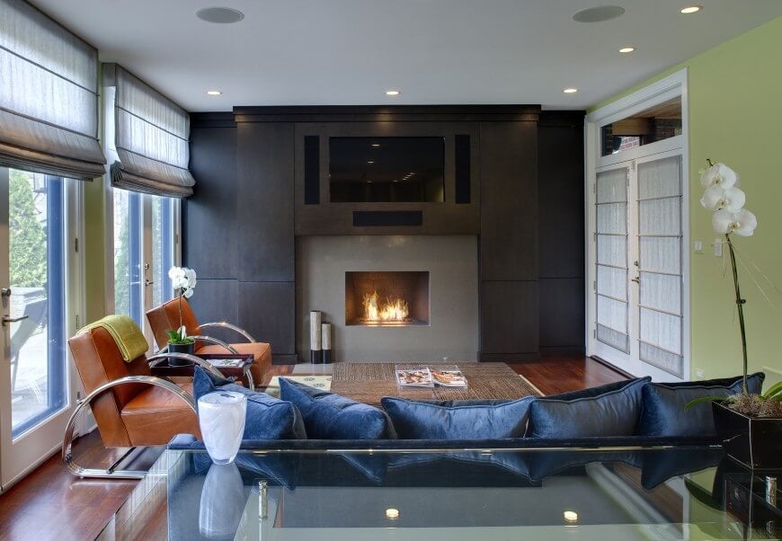 舒适的当代家庭房设计，木地板和一面带有定制深色木镶板的墙壁，框架燃气壁炉。