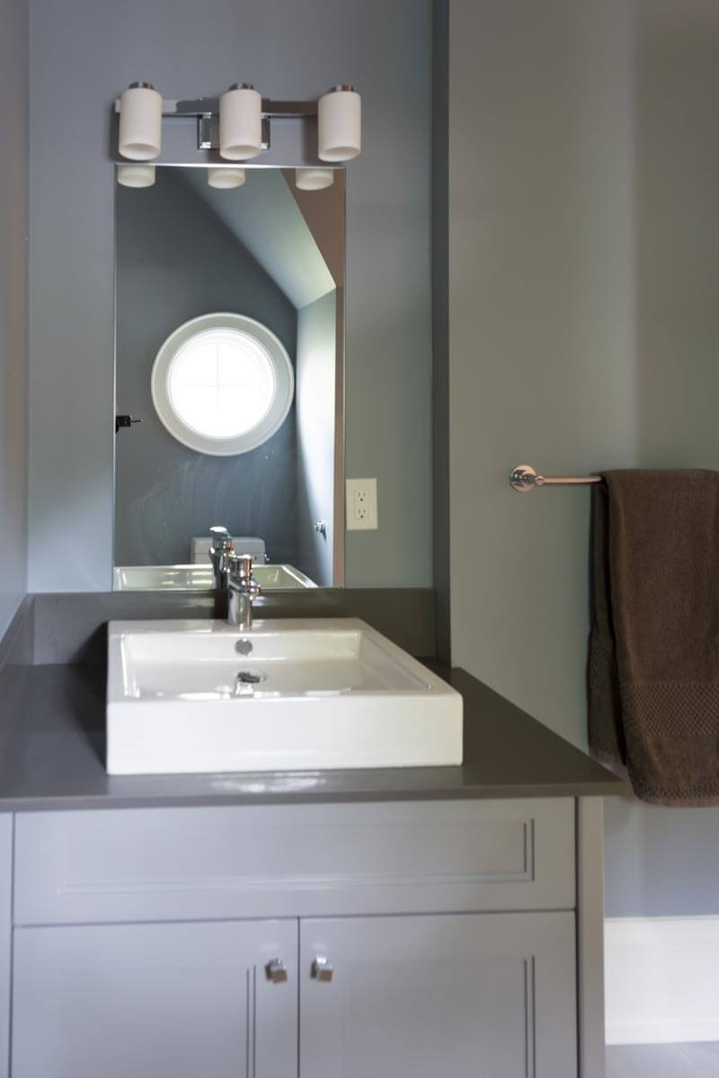 第二间浴室设有舒适的梳妆台和方形白色陶瓷容器水槽。