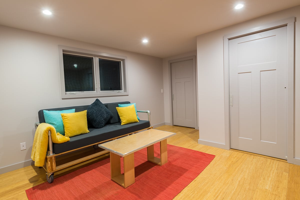 楼下的家庭娱乐室里有和楼上一样的家具，只是混合了一些新的强调色，包括粉色、黄色和蓝色。浅色的硬木地板与主楼层明亮的地板不同。