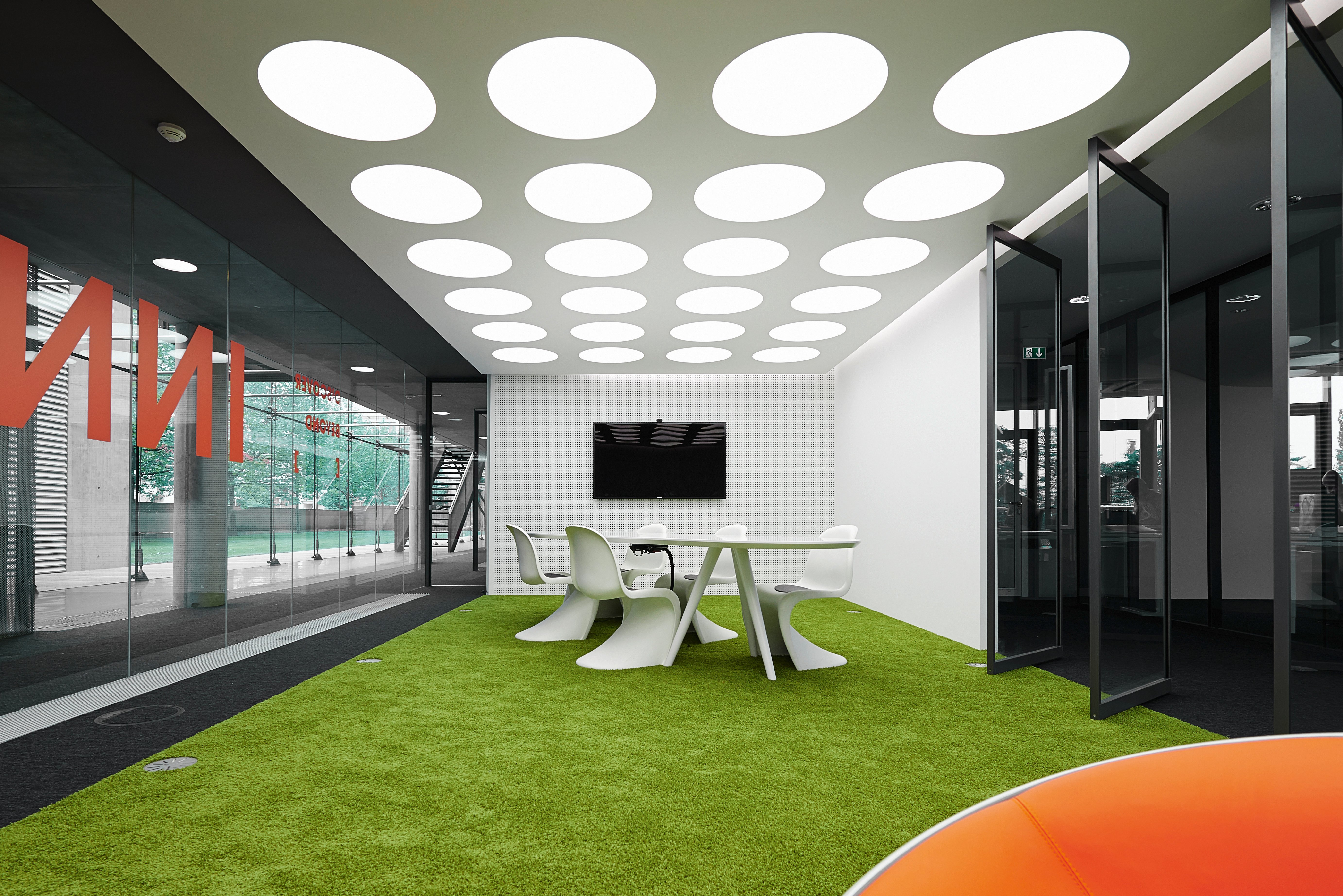 从广泛的角度来看，我们看到色彩鲜艳的独立会议空间坐落在两个中性色调的办公室之间，为建筑增添了色彩。