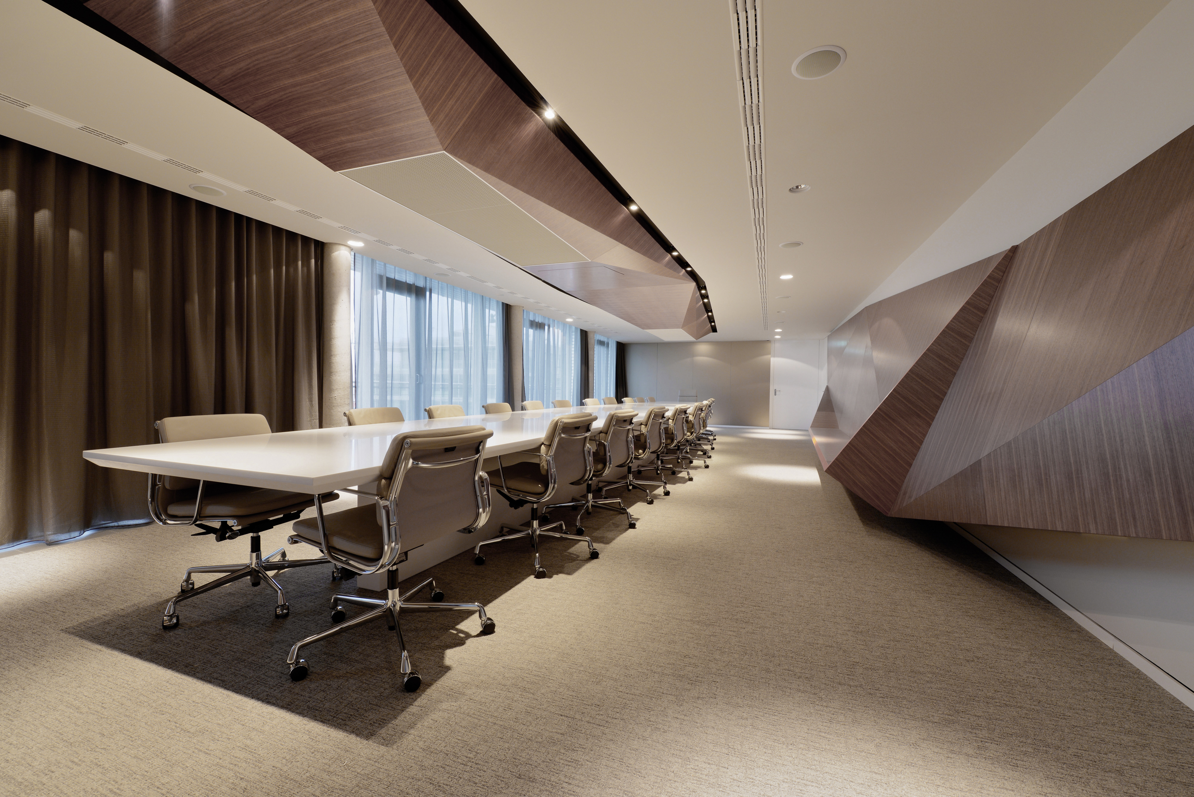 这个广阔的会议空间展示了多边形结构的大形式版本，在这里采用了天然木材色调。这些几何形状打破了办公室的标准直角形式，提供了独特而尖锐的工业创意元素。