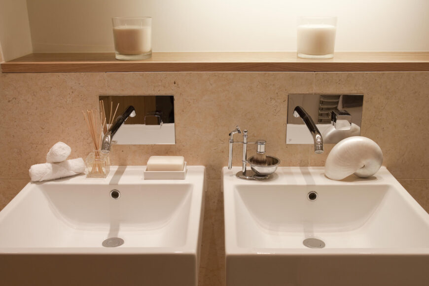 浴室设有一对浮动底座水槽作为梳妆台，上面有墙上安装的水龙头。