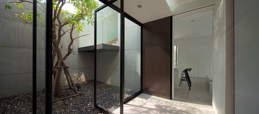 在这个空间中，通高的玻璃面板向一个僻静的花园区域开放，玻璃包裹的楼梯位于中心。
