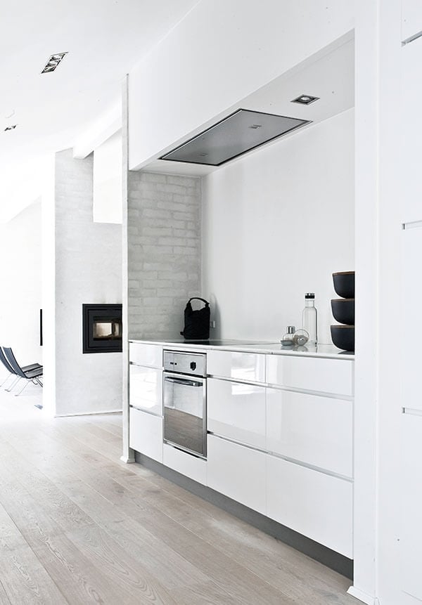 光滑的白色橱柜搭配不锈钢用具，形成强烈的对比，现代的外观。