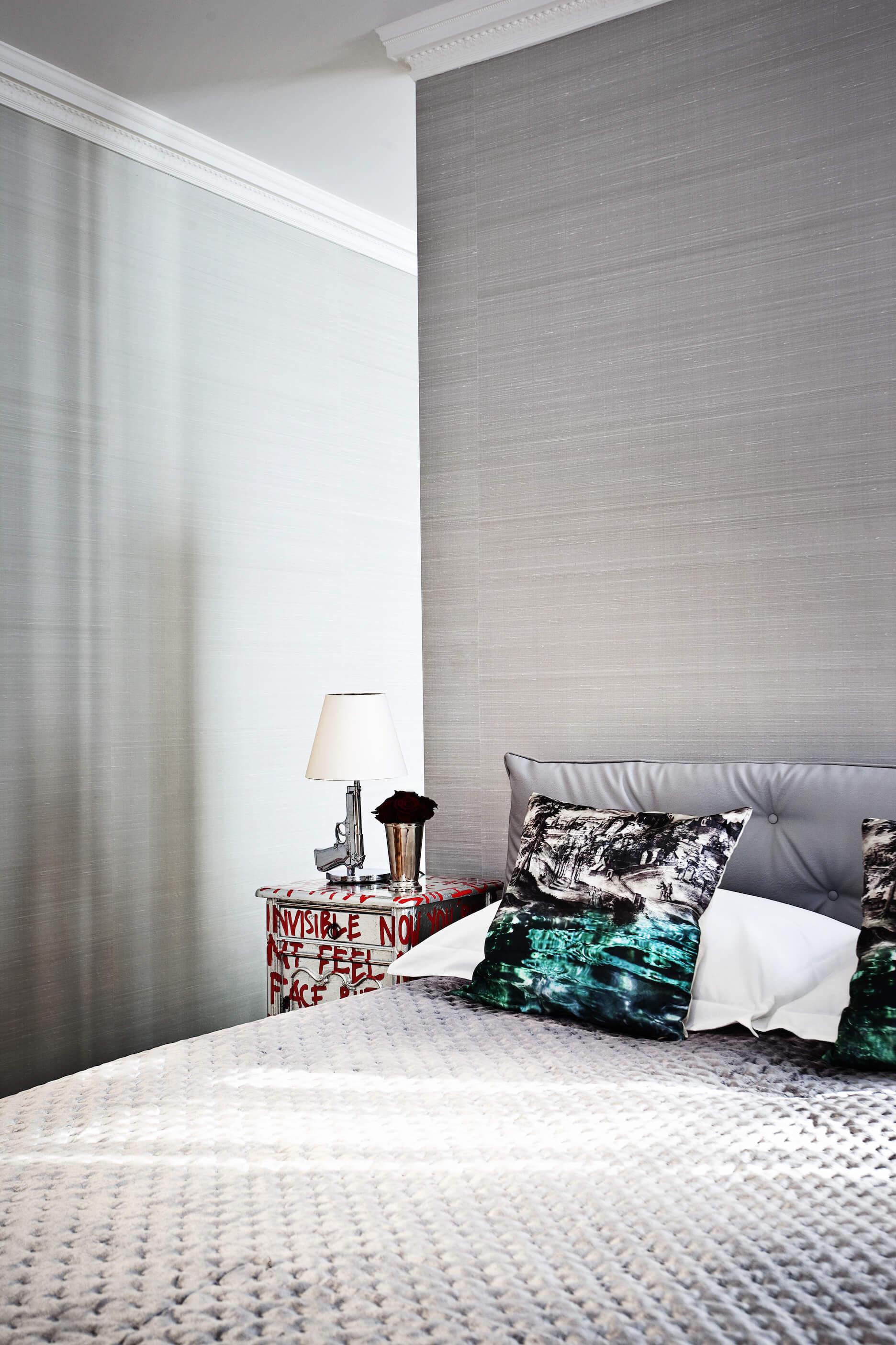 另一间卧室风格完全转变，以银色调突出，刷墙上方是一套独特的纹理床。