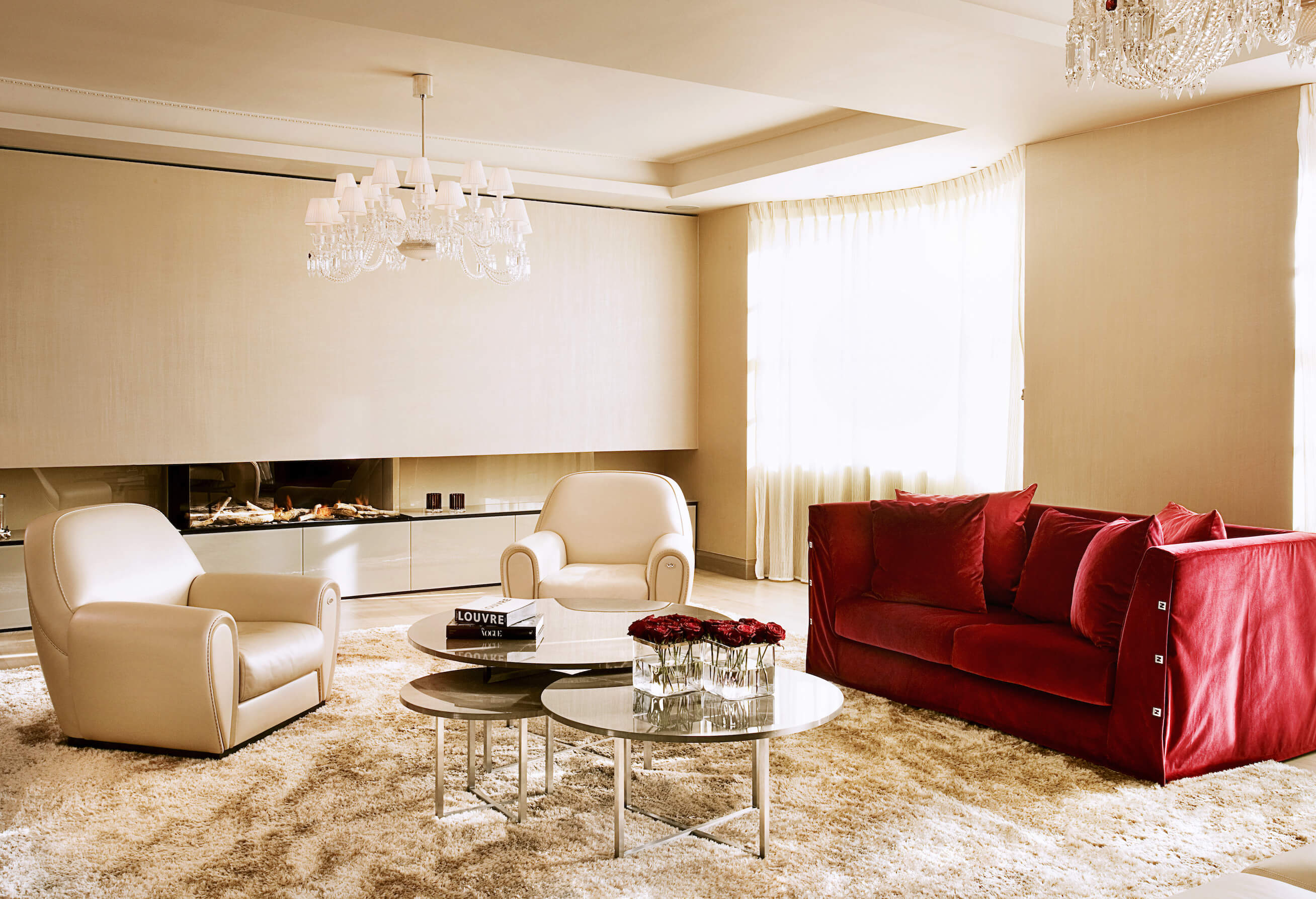 由Roselind Wilson Design设计的丰富的金色色调客厅和红色沙发