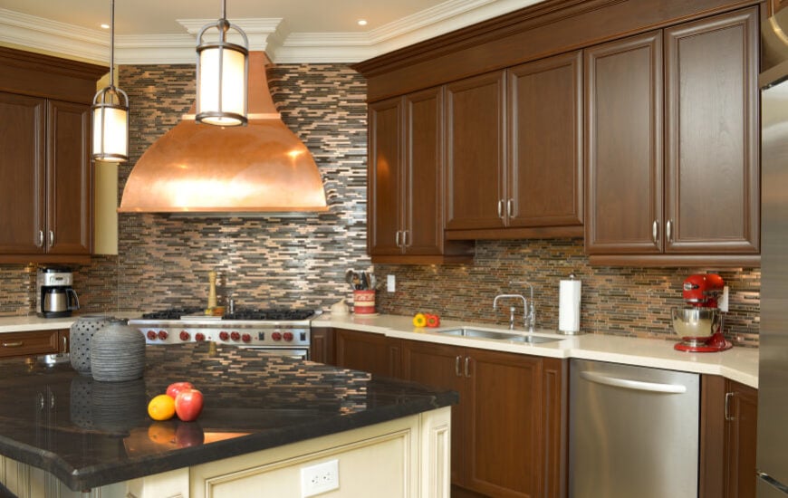 厨房有一个有趣的玻璃瓷砖后挡板，根据光线的角度看起来不同。铜元素为设计增添了光彩