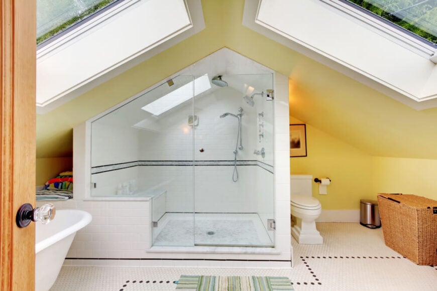 尖顶屋顶下的阁楼浴室，有两扇巨大的天窗。巨大的淋浴房包括一张长凳和自己的天窗。左边是一个独立的浴缸和一个放毛巾的角落。