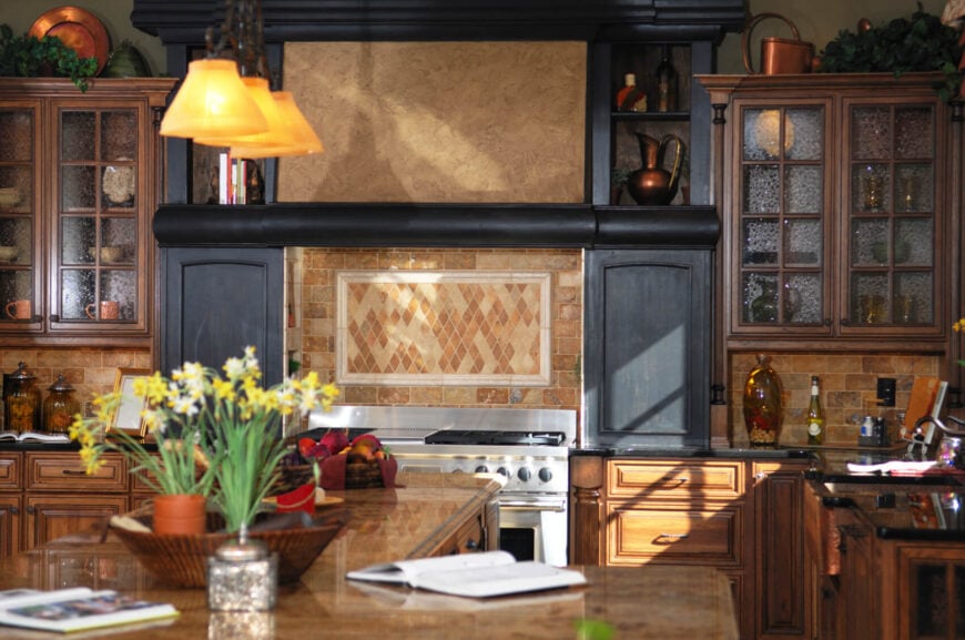 暗棕色和红色的石头瓷砖模仿了轻砖的外观，使这个厨房保持低调和传统。