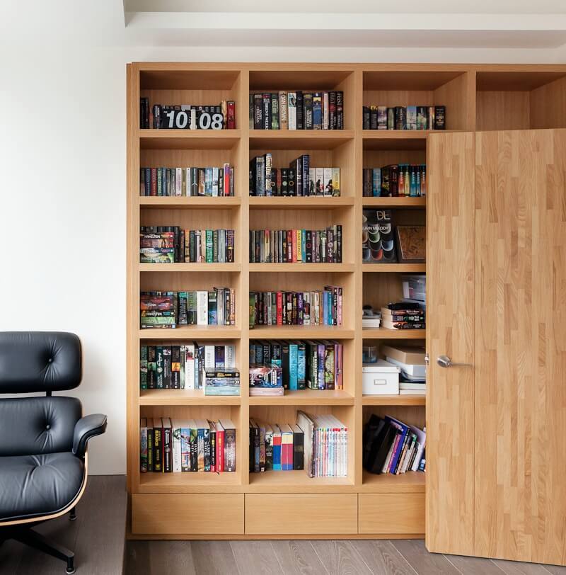 家庭办公室的特点是书桌和椅子所在的地板较高，较低的部分有漂亮的天然木质书柜。