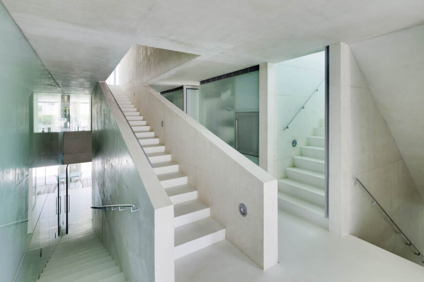 这是中央的“缓慢”楼梯，蜿蜒穿过房子的中心。白色和海蓝宝石玻璃的混合为整个空间注入了一种通风的平静。
