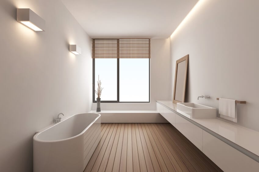 现代主浴室设有独立浴缸和容器水槽，以及白色墙壁和天花板包围的硬木地板。