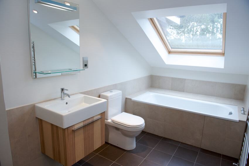 这个极简主义的浴室具有干净的线条、现代的设计和一个大天窗，每天将阳光注入这个较小的区域。