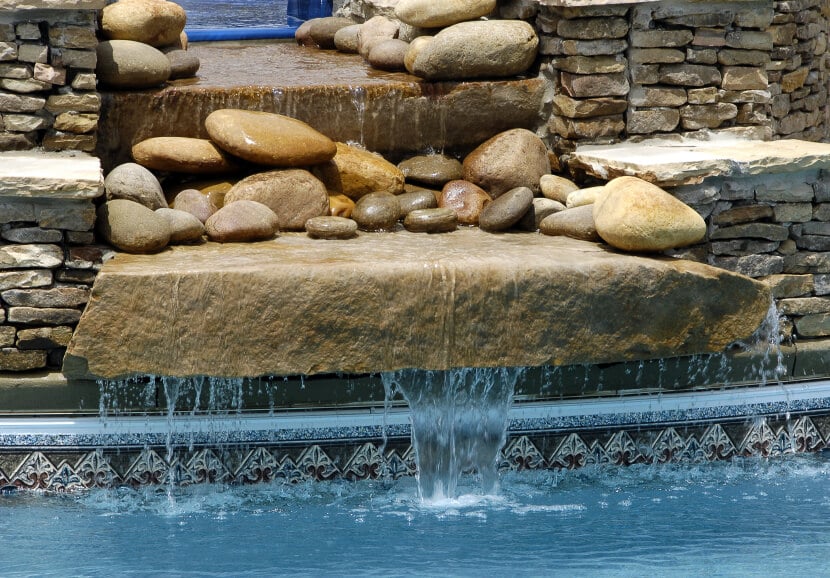 上述瀑布的视图，显示了两侧的多层和层状石。水从顶层的储层再循环。