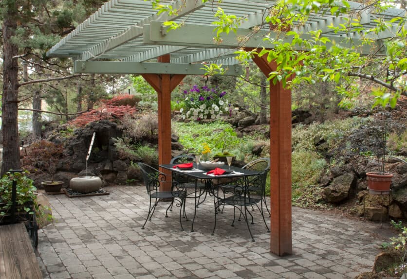 这座日式禅宗花园融合了更多西方元素，包括藏在绿色凉棚下的锻铁餐具。传统的竹石器皿喷泉营造出宁静的氛围。