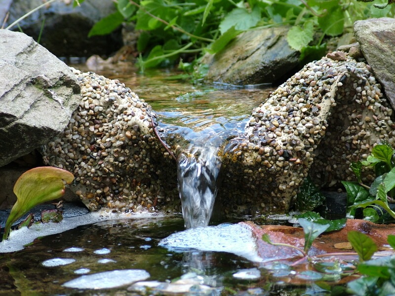 一个人造花园瀑布，当仔细观察时，是一种壮观的景象。即使是最小的瀑布也会产生涟漪、气泡和舒缓的声音。