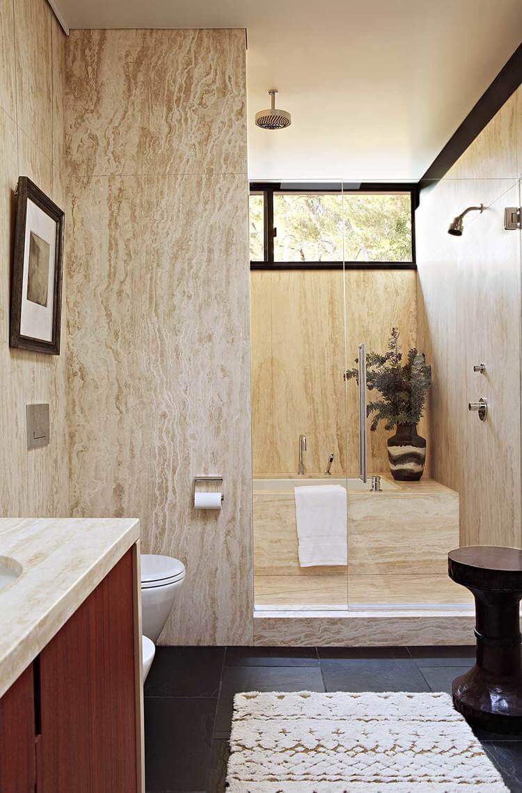 这间上世纪中叶的主浴室设有黑色瓷砖地板和高高的天花板。它还设有一个非常吸引人的淋浴和浴缸区。