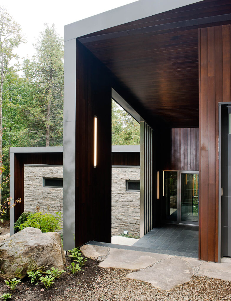 在到达金属框架玻璃门之前，深色瓷砖与丰富的木镶板形成对比。