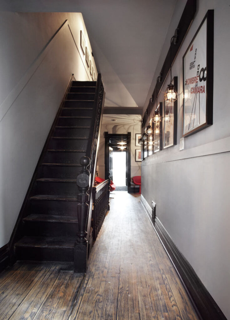 这座住宅的广阔走廊由原始的深色楼梯连接，在整个住宅中创造了一套重复的颜色。明亮的家具形成鲜明对比。