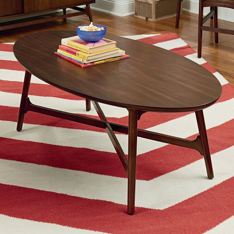 这款大而经典的咖啡桌采用深棕色木材制成，纤细优雅的桌腿之间有一个坚固的横条框架。