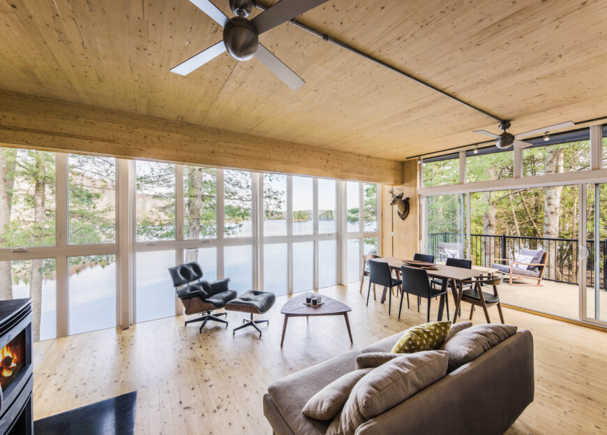 宽敞的开放式空间包括放置各种客厅家具的空间，以及一张长长的天然木质餐桌，餐桌位于完全打开的滑动玻璃门附近。