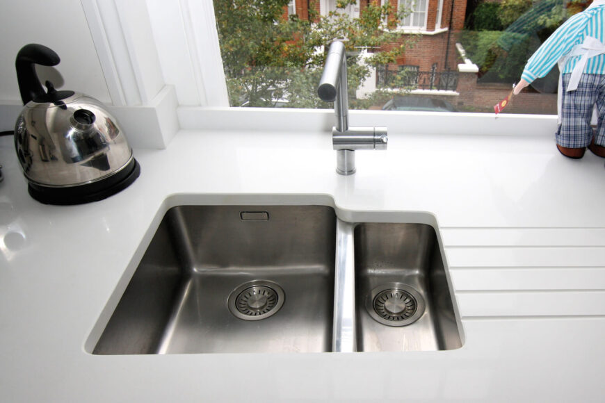 独特的水槽设计将盆嵌入厚实的白色台面中。在这里我们可以看到这个厨房的景色。