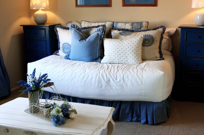 白色和矢车菊色的枕头掩盖了床上用品，并将房间完美地结合在一起。