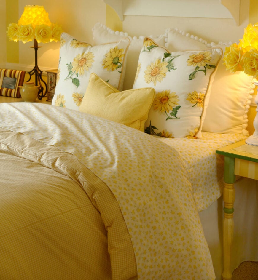 这个明亮的、阳光明媚的黄色空间很吸引人。混合了各种各样的图案和协调的颜色，这个卧室区域是动态的和有趣的。明亮的黄色玫瑰灯罩在这个可爱而放松的房间里是一个真正的亮点。