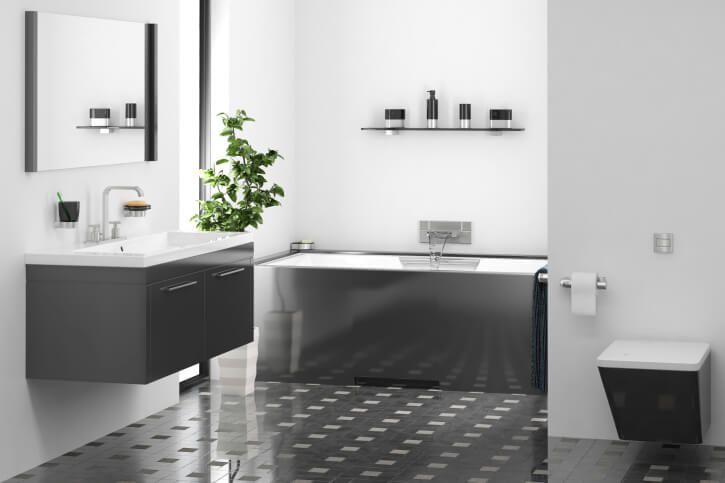 这是一间极简主义的浴室，上面铺着深灰色和白色小方块组成的精细瓷砖地板。原始的白色墙壁和水槽与橱柜和地板形成对比。