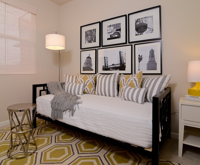 这张深黑色的沙发床在第二间卧室中提供了灵活的座位或睡眠，上面有蜂巢图案的地毯。