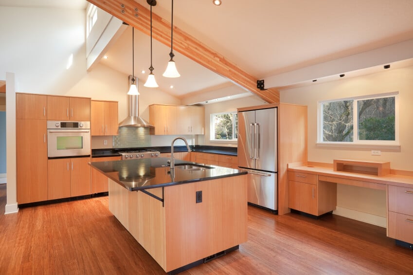 这个明亮的厨房利用倾斜的天花板来增加兴趣，而台面和温暖的木地板增加了重量，并有助于这个通风的空间。