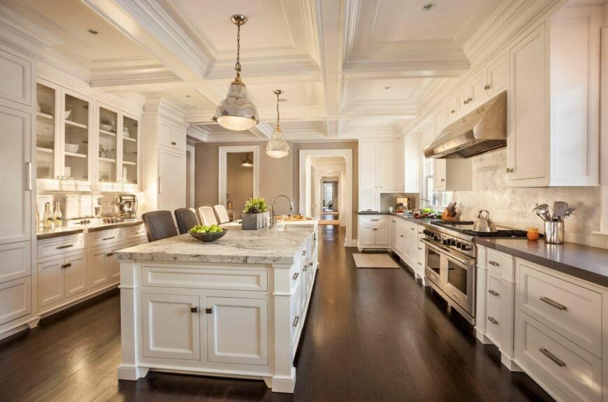 宽敞的厨房是美丽的白色，与宽阔的深色硬木地板形成对比。长铬手柄与不锈钢高端电器相得益彰。巨大的大理石屋顶的厨房岛有一个可供四人用餐的酒吧。