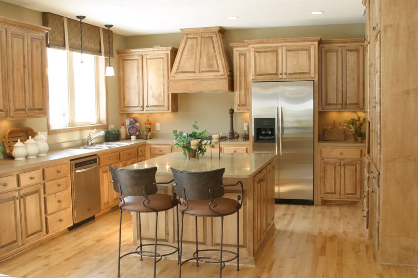 这个厨房里可爱的浅色木材使房间感觉非常明亮和开放。单一的色调覆盖了从地板到上面的所有东西，并被不锈钢用具所点缀。