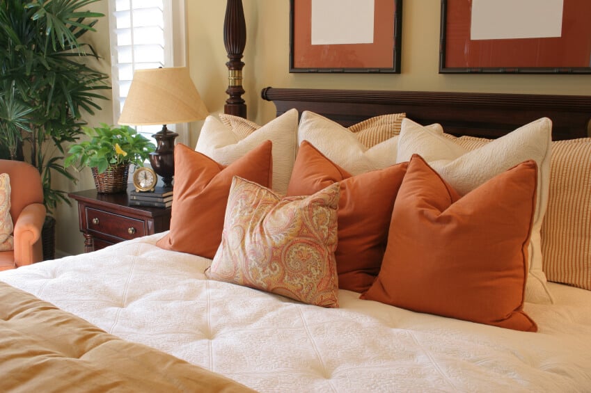 这个明亮开朗的空间提供了可爱的色彩，充满活力的铁锈色的重点枕头和协调椅。一个可爱的涡纹花纹抱枕走在前面，同时支持条纹和奶油色的枕头使这个特殊的组合更加完美。