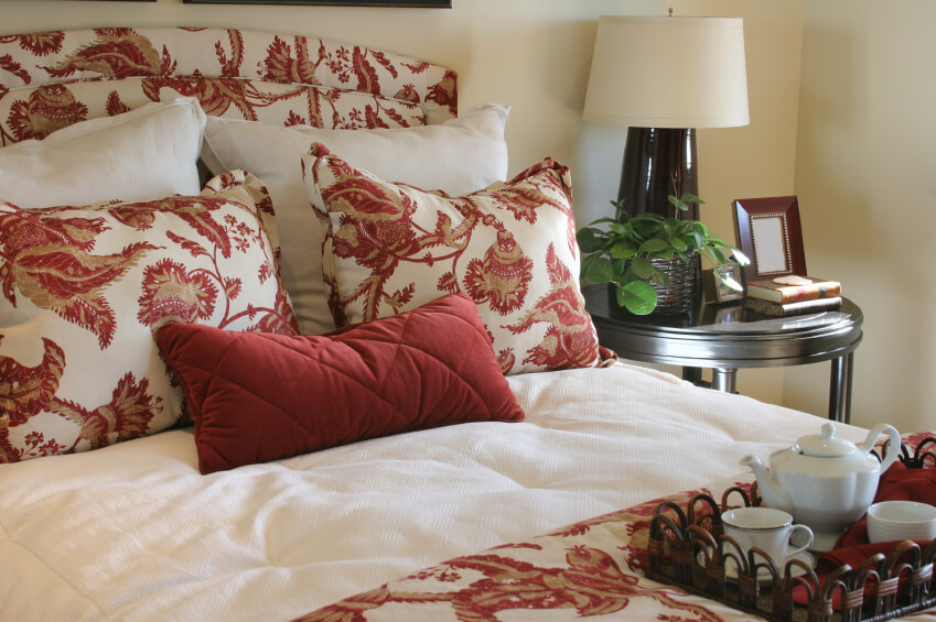 匹配的床头板，枕头，羽绒被被白色枕头和深红色腰枕打断。