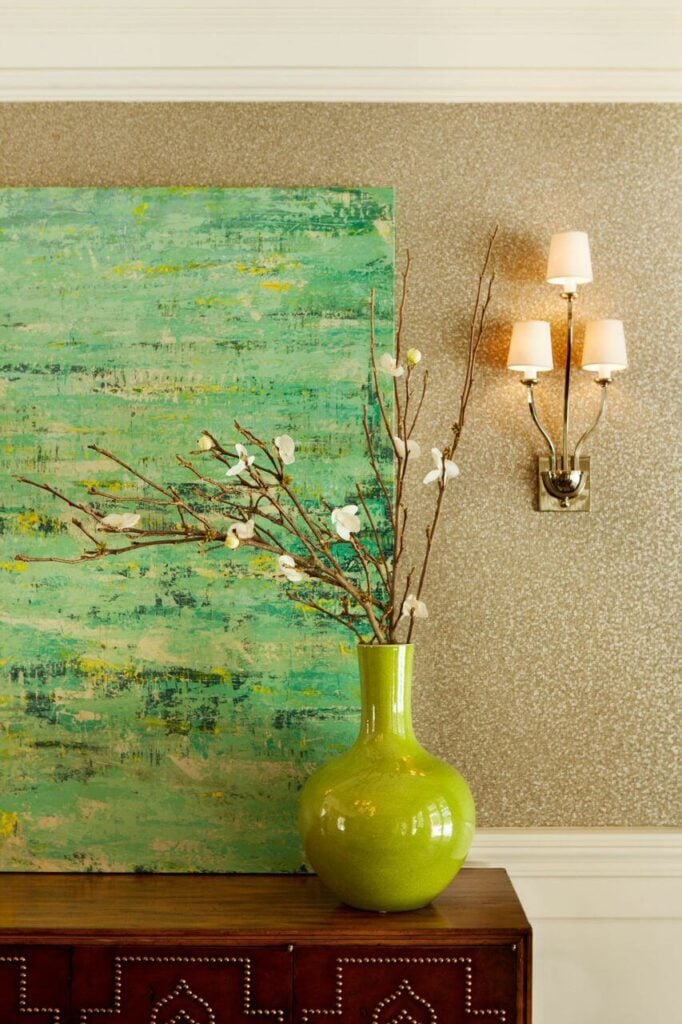 餐厅自助餐的特写，集中在斑点墙壁和口音上。在画中，盛满山茱萸花的灰绿色花瓶也呈现出同样的绿色。