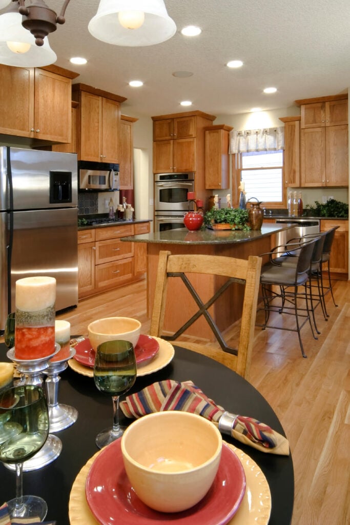 这个厨房里的暖色木材加强了所选的强调色。全高橱柜的使用统一了房间的色调。