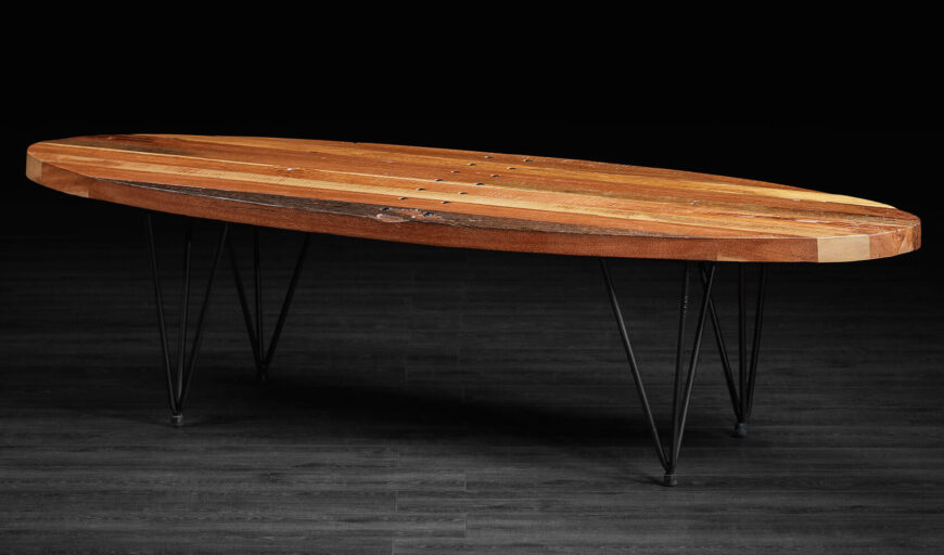 这张咖啡桌是一个引人注目的当代设计，在三角形线框腿上融合了更像冲浪板的表面。丰富的天然木材和薄黑色金属的混合构成了一个令人振奋的组合。