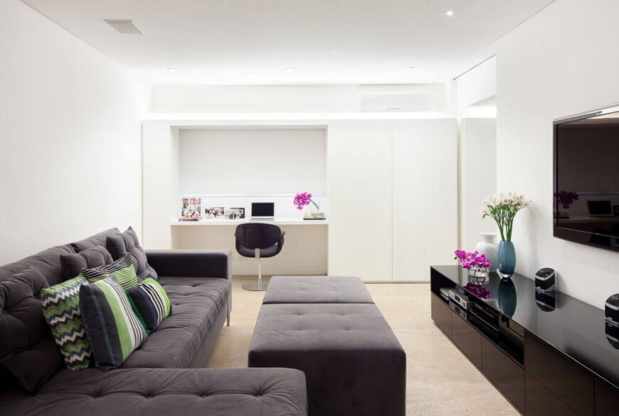 家庭娱乐室与家庭办公室相结合，创造了一个舒适的非正式放松空间。像房子的其他地方一样，墙壁是清新的白色，配有极简主义的储物柜。纽扣簇节有双脚垫。