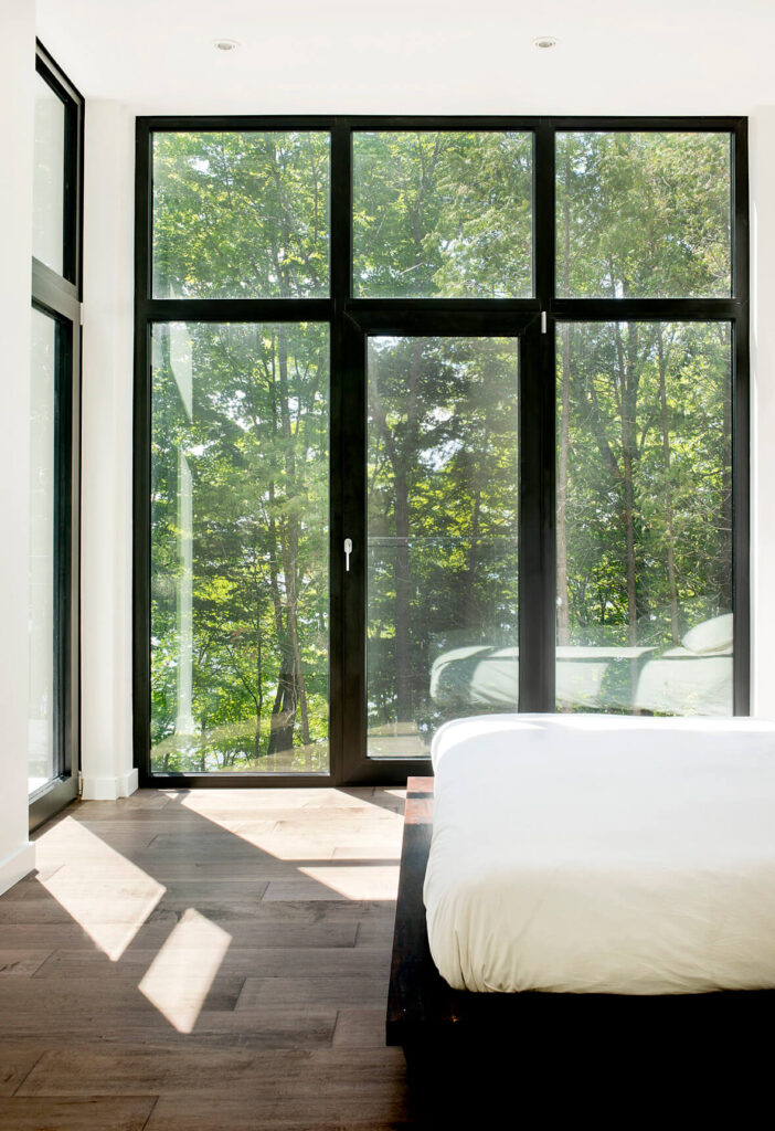 在顶层，主卧室享有周围森林和远处湖泊的广阔视野。