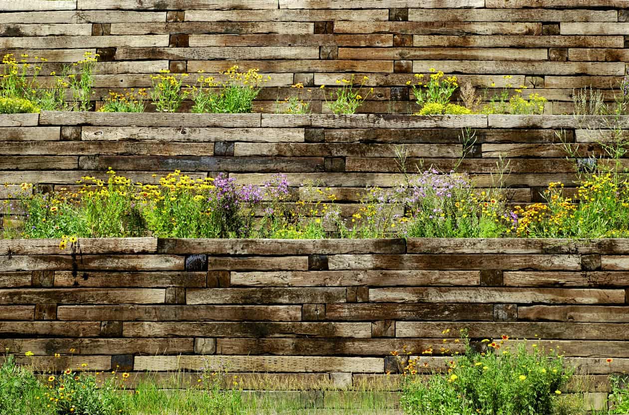 华丽的木砖挡土墙与堆叠的概念，可爱的绿色植物强调。其层次感的设计与内聚力的外观使其赏心悦目。
