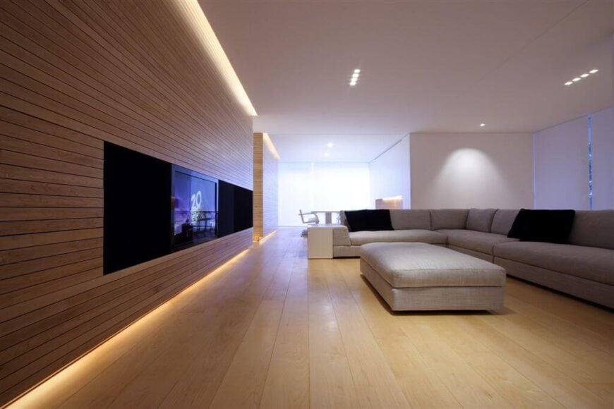 这个开放式的平面设计有很多隐藏的灯。浅色硬木地板让柔和的灯光在整个家庭强调天然木材。