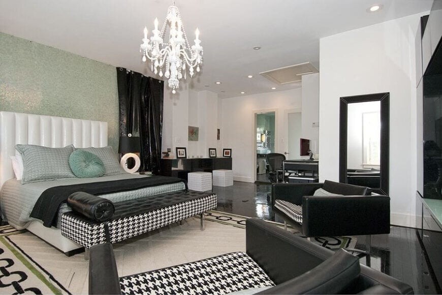 现代风格的主卧室，黑色人造革和犬牙花纹织物制成的深沙发。床后面的墙贴着闪闪发光的海绿色马赛克瓷砖。
