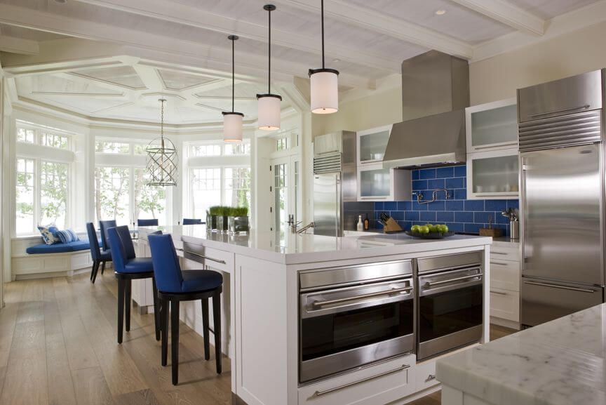 这个充满活力的厨房设计绝对令人惊叹。厨房的后挡板和座椅都是宝蓝色的，这个别致的空间有着完美的对比。大型优雅风格的窗玻璃创造了一个形状优美的入口，进入这个宏伟的房间。